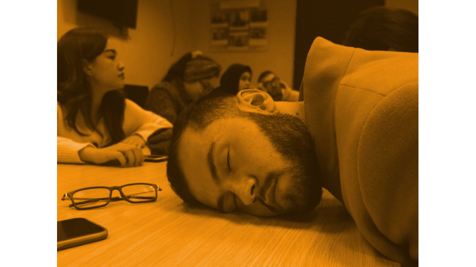 A person sleeping in the middle of a meeting.