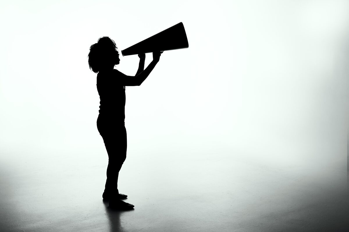 silhouette of an adult holding a megaphone, as if to announce something.